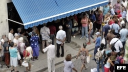 Decenas de personas hacen cola frente a una Casa de Cambio (CADECA) para cambiar sus dólares por pesos cubanos, hoy miércoles 27 de octubre, en La Habana (Cuba). Las CADECAS continúan recibiendo una avalancha de cubanos, muchos de ellos ancianos, deseosos