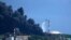 Un helicóptero derrama agua de mar sobre uno de los tanques incendiados. Los bomberos cubanos, junto a técnicos y especialistas de México y Venezuela, intentaban sofocar las llamas este domingo. (AP/Ramon Espinosa)