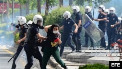 Un policía antidisturbios forcejea con una manifestante durante una de las revueltas que sacuden Turquía desde el viernes pasado, en Ankara.