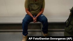 ARCHIVO - Un inmigrante aguarda a ser procesado por agentes de inmigración en un centro de detención en EEUU, el 6 de enero de 2022.