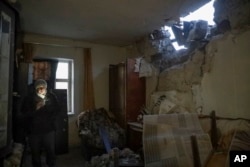 Una mujer dentro de su vivienda en Donetsk, en lo que las autoridades rusas dicen fue un ataque de las fuerzas ucranianas. (AP Photo)