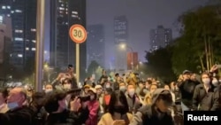 Manifestantes gritan consignas en protestas contra restricciones por el Covid-19, en Chengdu, China. (Foto: Video obtenido por REUTERS).