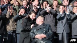 Kim Jong Un y su hija junto a funcionarios e ingenieros del régimen norcoreano, que contribuyeron a la prueba de fuego del nuevo misil balístico intercontinental. (Foto: KCNA VIA KNS / AFP)