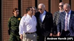 El presidente Joe Biden conversa con el congresista demócrata Henry Cuellar miestras caminan a lo largo de la frontera con México, en El Paso, Texas. (AP/Andrew Harnik)