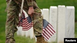 Un soldado de EEUU participa en la misión anual "Flags In" para el Día de los Caídos, en el Cementerio Nacional de Arlington. REUTERS/Kevin Lamarque