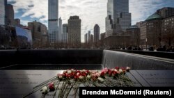 Flores cubren los nombres de las víctimas del atentado al World Trade Center tras una ceremonia en el 22 aniversario del ataque, en el Museo y Memorial Nacional del 11 de Septiembre, en Nueva York. (REUTERS/Brendan McDermid)