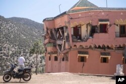 Un hombre de pie junto a un hotel dañado por un sismo en el poblado de Moulay Brahim, cerca del epicentro del sismo, a las afueras de Marrakech, Marruecos, el sábado 9 de septiembre de 2023. (AP Foto/Mosa'ab Elshamy)