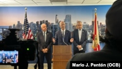 El senador Rick Scott (en el podio) junto a los congresistas Mario Díaz-Balart (derecha) y Carlos A. Giménez (izquierda) en el Aeropuerto Internacional de Miami, el 24 de mayo de 2024. (OCB Image).