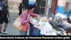 FOTO ARCHIVO. Una mujer registra un basurero en La Habana.