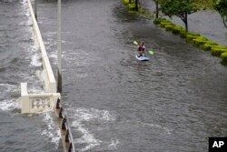 Zeke Pierce monta su paddle board en medio de un Bayshore Boulevard inundado en el centro de Tampa. (AP/Chris O'Meara)