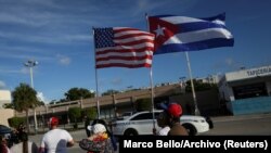 Emigrados ondean banderas estadounidenses y cubanas frente al restaurante Versailles, en Miami. (REUTERS/Marco Bello/Archivo).