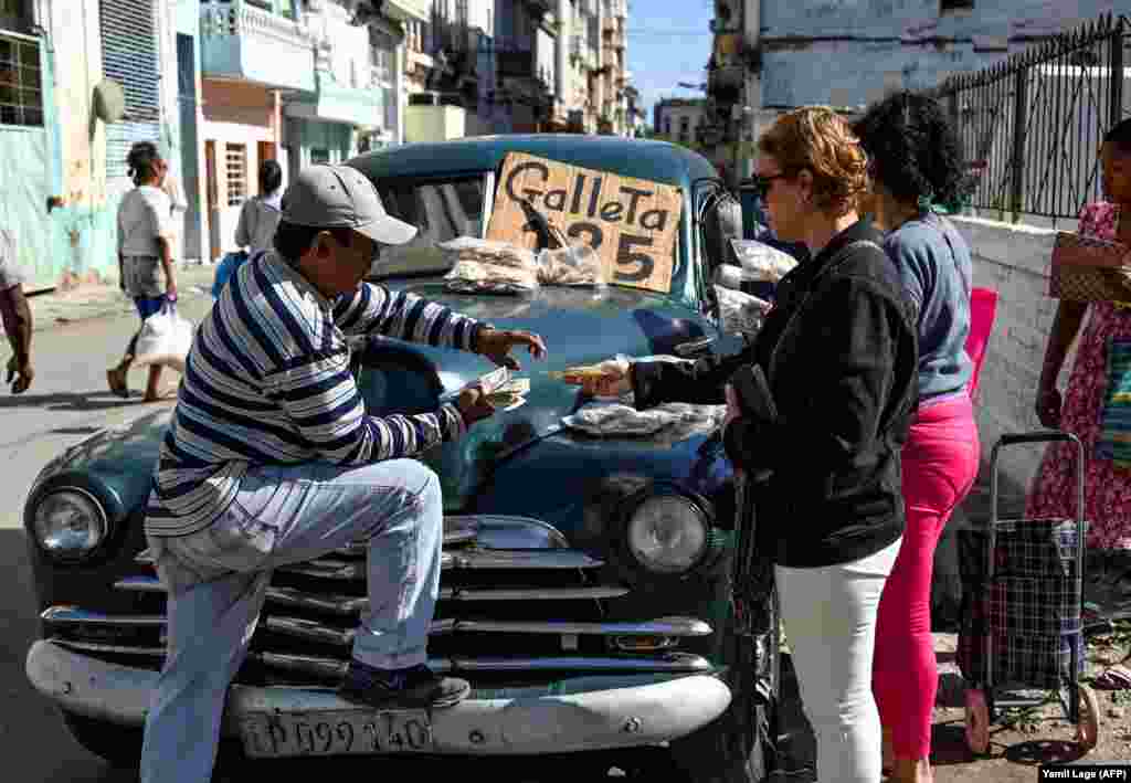 Un hombre vende galletas en un viejo auto estadounidense, en La Habana, el 20 de diciembre de 2023.