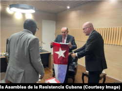 Rodrigo Arias Sánchez (centro) recibe la bandera cubana del 10 de octubre de 1868.