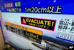 Una televisión muestra un aviso de tsunami, en Yokohama, cerca de Tokio, que luego fue descontinuado, el 1 de enero de 2024. (AP Foto/Eugene Hoshiko)