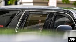 El ex presidente Donald Trump saluda desde el auto que le conduce por las calles de Miami. 