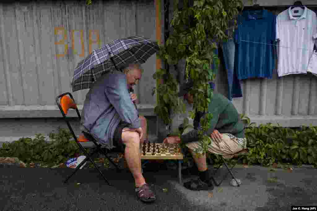 Dos vendedores juegan al ajedrez en el mercadillo callejero de Pochaina, en Kyiv, Ucrania, el 8 de julio de 2023. 