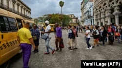 Cubanos hacen cola para trasladarse en el transporte público en La Habana, el 20 de diciembre de 2023. La tarifa del transporte público subirá en 2024. (Yamil Lage/AFP).