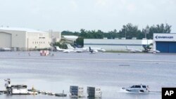 Un camión conduce por la pista inundada del Aeropuerto Internacional de Fort Lauderdale-Hollywood, el jueves 13 de abril de 2023, en Fort Lauderdale, Florida. (AP Photo/Marta Lavandier)