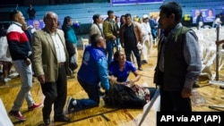 Una mujer simpatizante del candidato presidencial Fernando Villavicencio yace herida tras el ataque por disparos en el que Villavicencio fue asesinado. (API vía AP)