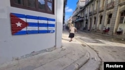 Anciana camina por una calle en Cuba.