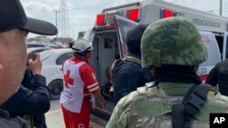 Un trabajador de la Cruz Roja cierra la puerta de una ambulancia que transporta a dos estadounidenses encontrados con vida después de su secuestro en Matamoros, México. (AP Foto)