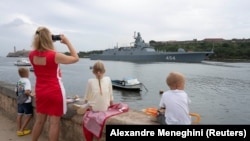 Miembros de la comunidad rusa en Cuba observan la entrada de la fragata Almirante Gorshkov a la bahía de La Habana, desde el Malecón. (REUTERS/Alexandre Meneghini)