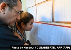 Cubanos buscan nombres de candidatos a diputados en un centro de votación en La Habana. ADALBERTO ROQUE / AFP