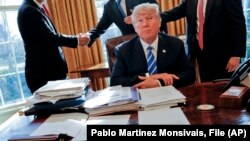 El expresidente Donald Trump en una imagen de archivo, sentado en su escritorio, en la oficina oval de la Casa Blanca, el 8 de febrero de 2017. (AP/Pablo Martinez Monsivais, File)