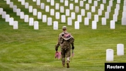 Un soldado de EEUU participa en la misión anual "Flags In" para el Día de los Caídos, en el Cementerio Nacional de Arlington. 