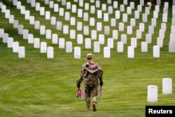 Un soldado de EEUU participa en la misión anual "Flags In" para el Día de los Caídos, en el Cementerio Nacional de Arlington. REUTERS/Kevin Lamarque