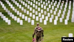 Un soldado de EEUU participa en la misión anual "Flags In" para el Día de los Caídos, en el Cementerio Nacional de Arlington. REUTERS/Kevin Lamarque