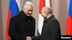Miguel Díaz-Canel y Vladímir Putin se estrechan la mano en una ceremonia en Moscú. (Sputnik/Sergey Guneev/Kremlin vía Reuters)
