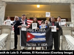 Miembros de la Asociación Cubano Americana de Kentucky (ACAK) posan con fotos de los presos políticos y las víctimas del régimen cubano en el Senado de Kentucky, el 8 de marzo de 2023.
