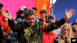 Nicolás Maduro, junto a su esposa Cilia Flores. El oficialismo proclamó a Maduro como candidato para buscar un tercer mandato presidencial. (AP/Jesús Vargas, Archivo)