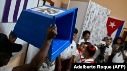 Una autoridad electoral muestra una urna vacía antes de iniciar los comicios legislativos de este domingo en Cuba. (ADALBERTO ROQUE / AFP)