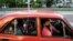 Cubanos viajan en auto usando mascarilla facial. (REUTERS/Alexandre Meneghini)