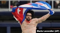 Carlos Manuel Álvarez se lanza el 19 de marzo de 2023 al terreno en el LoanDepot Park de Miami con la bandera cubana en alto, en protesta contra la dictadura comunista (AP/Marta Lavandier).