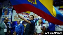 El candidato presidencial Fernando Villavicencio ondea una bandera de Ecuador en un acto de campaña en un colegio minutos antes de ser asesinado a tiros a la salida de ese recinto educativo en Quito, Ecuador, el miércoles 9 de agosto de 2023 (API vía AP)