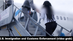 Una inmigrante cubana sube al avión que la llevará de regreso a la isla en un vuelo de deportación. Tomado de un video de Corey Bullard para ICE.