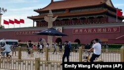 Residentes pasan junto a una camioneta de la policía estacionada frente a la Puerta de Tiananmen, en Beijing, este domingo 4 de junio de 2023. (AP/Emily Wang Fujiyama)