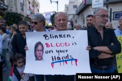 Palestinos protestan con carteles que rezan: "Blinken, tienes sangre en las manos".