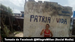 La activista Milagro Cervera posa junto al muro en el que escribió mensajes antigubernamentales.