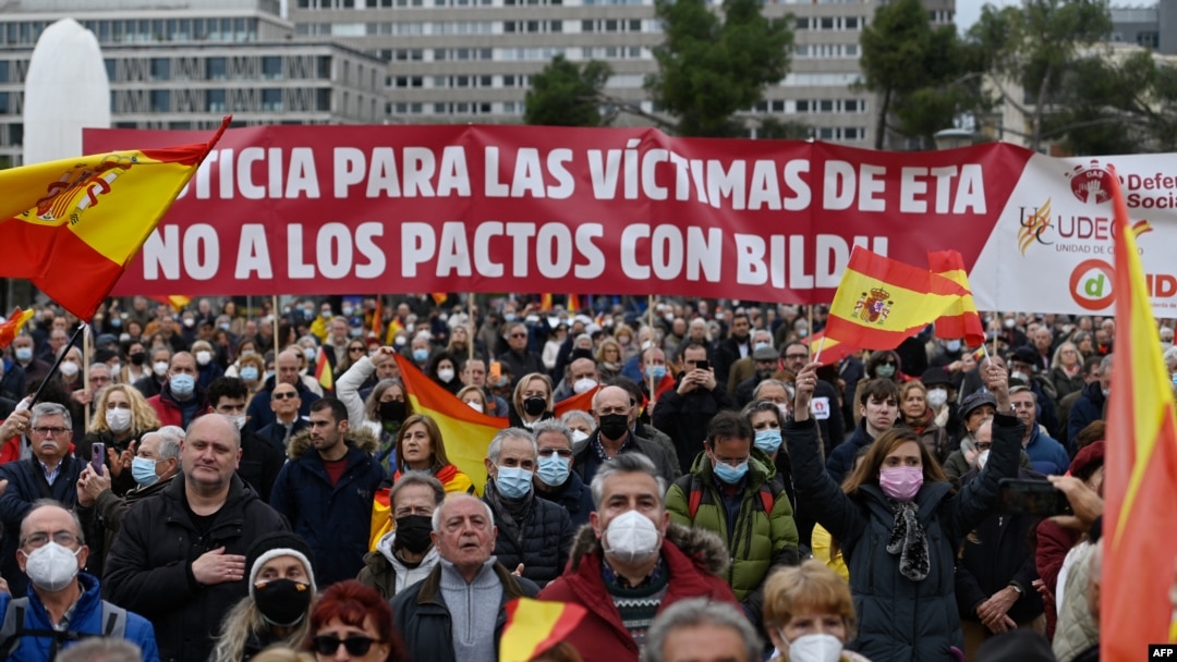 Manifestantes sostienen una pancarta en la que se lee "Justicia para las víctimas de ETA, no se pacta con Bildu", durante una manifestación organizada por la Asociación de Víctimas del Terrorismo (AVT). Plaza Colón de Madrid, el 26 de marzo de 2022. (Foto de OSCAR DEL POZO / AFP)