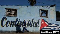 Un hombre pasa junto a un cartel que reza "Continuidad", el lema del gobierno de Miguel Díaz-Canel. (Yamil Lage/AFP)