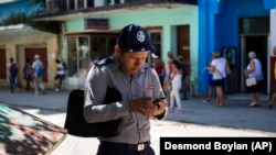 Un policía se conecta a Internet usando un teléfono celular en La Habana (AP/Desmond Boylan/Archivo)