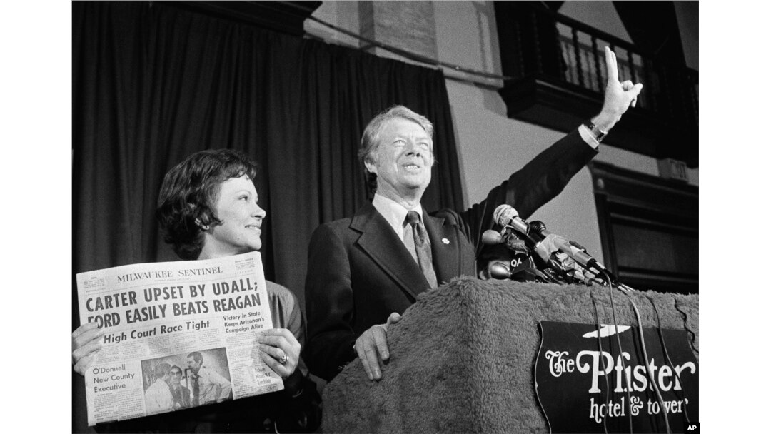 Jimmy Carter hace la señal de la victoria junto a su esposa, Rosalynn Carter, después de ganar la primaria presidencial demócrata de Wisconsin, en 1976. (AP Foto/Paul Shane, Archivo)