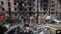 Trabajadores de los servicios de emergencias inspeccionan los daños causados en un edificio de varias plantas por un ataque ruso, en Krivói Rog, Ucrania, el 13 de junio de 2023. (AP Foto/Andriy Dubchak)