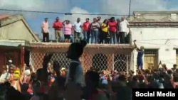 Desde la azotea de una vivienda, las autoridades locales, encabezadas por la gobernadora Beatriz Johnson Urrutia, intentan aplacar a los manifestantes en Santiago de Cuba, el 17 de marzo de 2024.