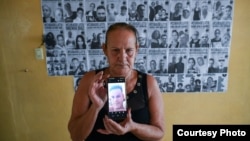 Lisette Fonseca, integrante de Cuba de Luto, muestra una foto de su hijo, Roberto Pérez Fonseca, preso político del 11J. (Foto: Cortesía de Albert Fonse)