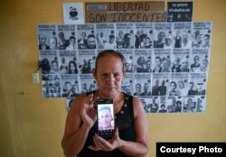 Lisette Fonseca, integrante de Cuba de Luto, muestra una foto de su hijo, Roberto Pérez Fonseca, preso político del 11J. (Foto: Cortesía de Albert Fonse)
